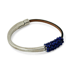 Artisan bracelet featuring a silver-tone half cuff and brown leather band, hand-stitched with faceted lapis beads and a signature gold accent; Martell Studio design, size 6 with magnetic clasp.