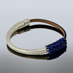 Artisan bracelet featuring a silver-tone half cuff and brown leather band, hand-stitched with faceted lapis beads and a signature gold accent; Martell Studio design, size 6 with magnetic clasp.