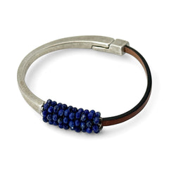 Artisan bracelet featuring a silver-tone half cuff and brown leather band, hand-stitched with faceted lapis beads and a signature gold accent; Martell Studio design, size 6 with magnetic clasp.