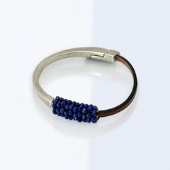 Artisan bracelet featuring a silver-tone half cuff and brown leather band, hand-stitched with faceted lapis beads and a signature gold accent; Martell Studio design, size 6 with magnetic clasp.