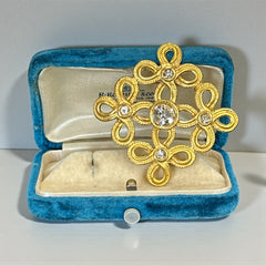 Vintage matte gold tone brooch with textured open loops and clear rhinestones, shown from different angles to highlight its square or diamond shape and detailed craftsmanship