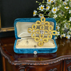 Vintage matte gold tone brooch with textured open loops and clear rhinestones, shown from different angles to highlight its square or diamond shape and detailed craftsmanship