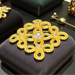 Vintage matte gold tone brooch with textured open loops and clear rhinestones, shown from different angles to highlight its square or diamond shape and detailed craftsmanship