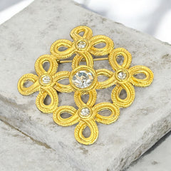 Vintage matte gold tone brooch with textured open loops and clear rhinestones, shown from different angles to highlight its square or diamond shape and detailed craftsmanship