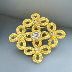 Vintage matte gold tone brooch with textured open loops and clear rhinestones, shown from different angles to highlight its square or diamond shape and detailed craftsmanship
