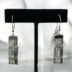 Vintage clear rhinestone and silver tone mesh dangle earrings with emerald-cut rhinestones and chaton accents, paired with sterling silver ear wires, photographed against a clean, neutral backdrop.
