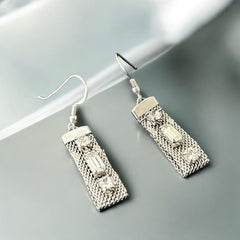Vintage clear rhinestone and silver tone mesh dangle earrings with emerald-cut rhinestones and chaton accents, paired with sterling silver ear wires, photographed against a clean, neutral backdrop.