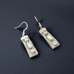 Vintage clear rhinestone and silver tone mesh dangle earrings with emerald-cut rhinestones and chaton accents, paired with sterling silver ear wires, photographed against a clean, neutral backdrop.