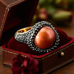 Vintage Honora Italy bronze ring featuring a 12.5mm orange cultured pearl surrounded by faceted black spinel; warm-toned statement jewelry with autumnal elegance and sculptural detail.