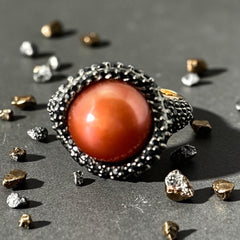 Vintage Honora Italy bronze ring featuring a 12.5mm orange cultured pearl surrounded by faceted black spinel; warm-toned statement jewelry with autumnal elegance and sculptural detail.
