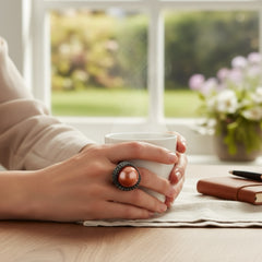 Vintage Honora Italy bronze ring featuring a 12.5mm orange cultured pearl surrounded by faceted black spinel; warm-toned statement jewelry with autumnal elegance and sculptural detail.