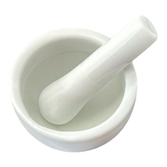 Elegant white porcelain mortar and pestle with glazed exterior and raw interior, designed for tabletop spice grinding and culinary rituals.