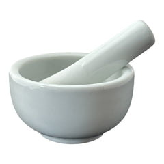 Elegant white porcelain mortar and pestle with glazed exterior and raw interior, designed for tabletop spice grinding and culinary rituals.