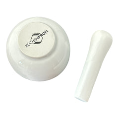 Elegant white porcelain mortar and pestle with glazed exterior and raw interior, designed for tabletop spice grinding and culinary rituals.