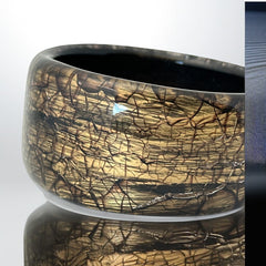 Glossy black and gold Lucite bangle with a freeform silhouette and layered, crackled texture; unsigned and sculptural.