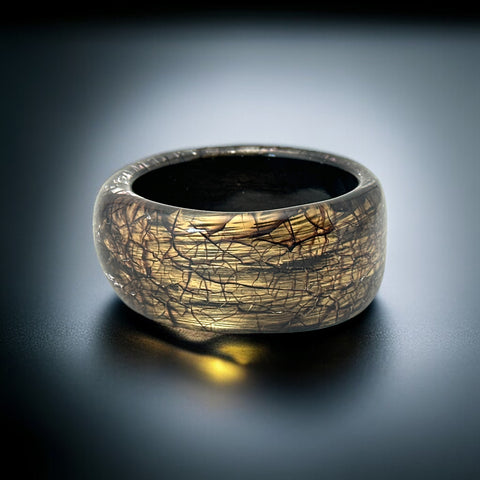 1970s 1980s Glossy black and gold Lucite bangle with a freeform silhouette and layered, crackled texture; unsigned and sculptural.