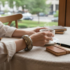 Glossy black and gold Lucite bangle with a freeform silhouette and layered, crackled texture; unsigned and sculptural.