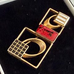 Vintage geometric modernist brooch with red, black, and white enamel in gold‑tone metal.