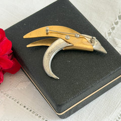 Vintage modernist bird brooch in gold and silver tone with pavé rhinestones and black enamel details.