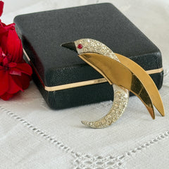Vintage modernist bird brooch in gold and silver tone with pavé rhinestones and black enamel details.