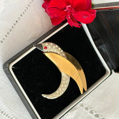 Vintage modernist bird brooch in gold and silver tone with pavé rhinestones and black enamel details.