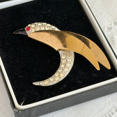 Vintage modernist bird brooch in gold and silver tone with pavé rhinestones and black enamel details.