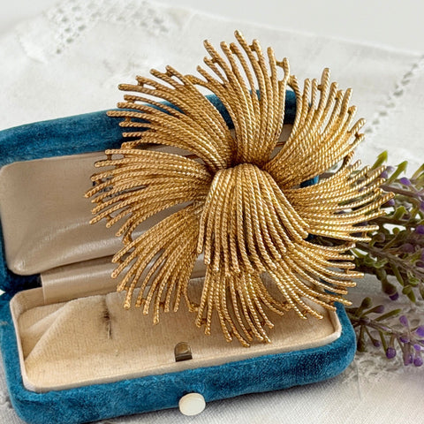 Vintage Monet Cordelia textured 22k gold plated wire starburst brooch with twisted rope‑style tendrils and signed back.