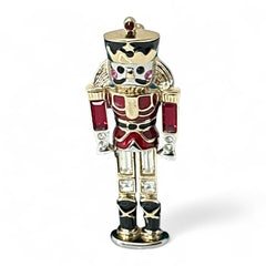 Vintage Monet nutcracker brooch with red and clear rhinestones, black and red enamel, and light gold tone finish, signed on back, holiday-themed costume jewelry in excellent condition