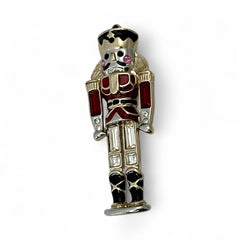 Vintage Monet nutcracker brooch with red and clear rhinestones, black and red enamel, and light gold tone finish, signed on back, holiday-themed costume jewelry in excellent condition