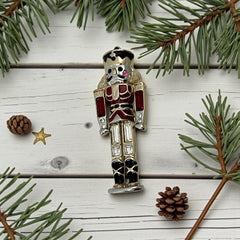 Vintage Monet nutcracker brooch with red and clear rhinestones, black and red enamel, and light gold tone finish, signed on back, holiday-themed costume jewelry in excellent condition