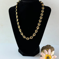 Vintage Monet gold‑tone chain link necklace with black accents, shown in various angles to highlight its adjustable length and signed hangtag.