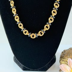 Vintage Monet gold‑tone chain link necklace with black accents, shown in various angles to highlight its adjustable length and signed hangtag.
