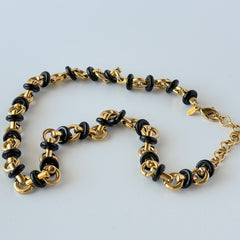 Vintage Monet gold‑tone chain link necklace with black accents, shown in various angles to highlight its adjustable length and signed hangtag.