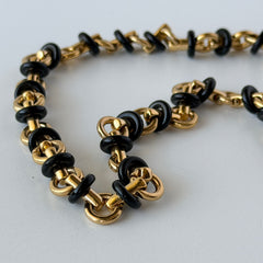 Vintage Monet gold‑tone chain link necklace with black accents, shown in various angles to highlight its adjustable length and signed hangtag.