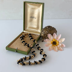 Vintage Monet gold‑tone chain link necklace with black accents, shown in various angles to highlight its adjustable length and signed hangtag.
