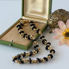 Vintage Monet gold‑tone chain link necklace with black accents, shown in various angles to highlight its adjustable length and signed hangtag.