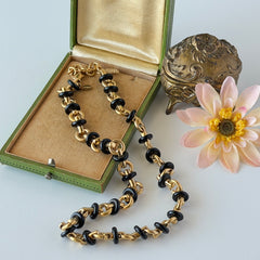 Vintage Monet gold‑tone chain link necklace with black accents, shown in various angles to highlight its adjustable length and signed hangtag.