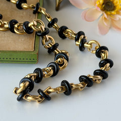 Vintage Monet gold‑tone chain link necklace with black accents, shown in various angles to highlight its adjustable length and signed hangtag.
