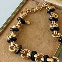 Vintage Monet gold‑tone chain link necklace with black accents, shown in various angles to highlight its adjustable length and signed hangtag.