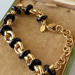 Vintage Monet gold‑tone chain link necklace with black accents, shown in various angles to highlight its adjustable length and signed hangtag.