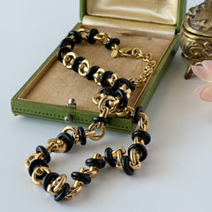 Vintage Monet gold‑tone chain link necklace with black accents, shown in various angles to highlight its adjustable length and signed hangtag.