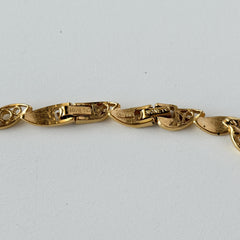 Vintage Monet gold‑tone marquise link necklace with alternating polished and openwork rhinestone links, shown in various angles to highlight its bright finish, signed clasp, and 16½‑inch length.
