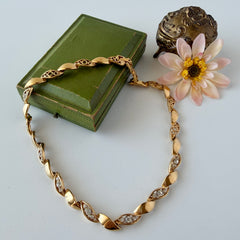 Vintage Monet gold‑tone marquise link necklace with alternating polished and openwork rhinestone links, shown in various angles to highlight its bright finish, signed clasp, and 16½‑inch length.