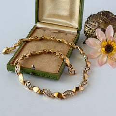 Vintage Monet gold‑tone marquise link necklace with alternating polished and openwork rhinestone links, shown in various angles to highlight its bright finish, signed clasp, and 16½‑inch length.