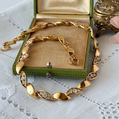 Vintage Monet gold‑tone marquise link necklace with alternating polished and openwork rhinestone links, shown in various angles to highlight its bright finish, signed clasp, and 16½‑inch length.