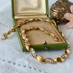 Vintage Monet gold‑tone marquise link necklace with alternating polished and openwork rhinestone links, shown in various angles to highlight its bright finish, signed clasp, and 16½‑inch length.