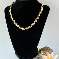 Vintage Monet gold‑tone marquise link necklace with alternating polished and openwork rhinestone links, shown in various angles to highlight its bright finish, signed clasp, and 16½‑inch length.