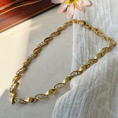 Vintage Monet gold‑tone marquise link necklace with alternating polished and openwork rhinestone links, shown in various angles to highlight its bright finish, signed clasp, and 16½‑inch length.