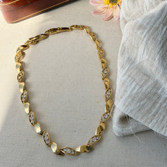 Vintage Monet gold‑tone marquise link necklace with alternating polished and openwork rhinestone links, shown in various angles to highlight its bright finish, signed clasp, and 16½‑inch length.