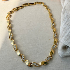 Vintage Monet gold‑tone marquise link necklace with alternating polished and openwork rhinestone links, shown in various angles to highlight its bright finish, signed clasp, and 16½‑inch length.